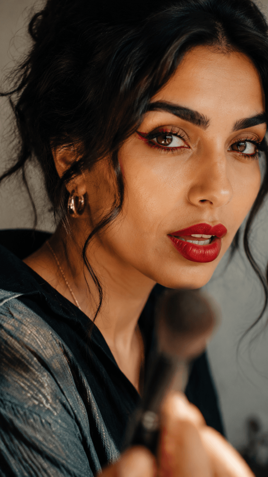 Temporary makeup close-up: a woman wearing red lipstick and holding a makeup brush